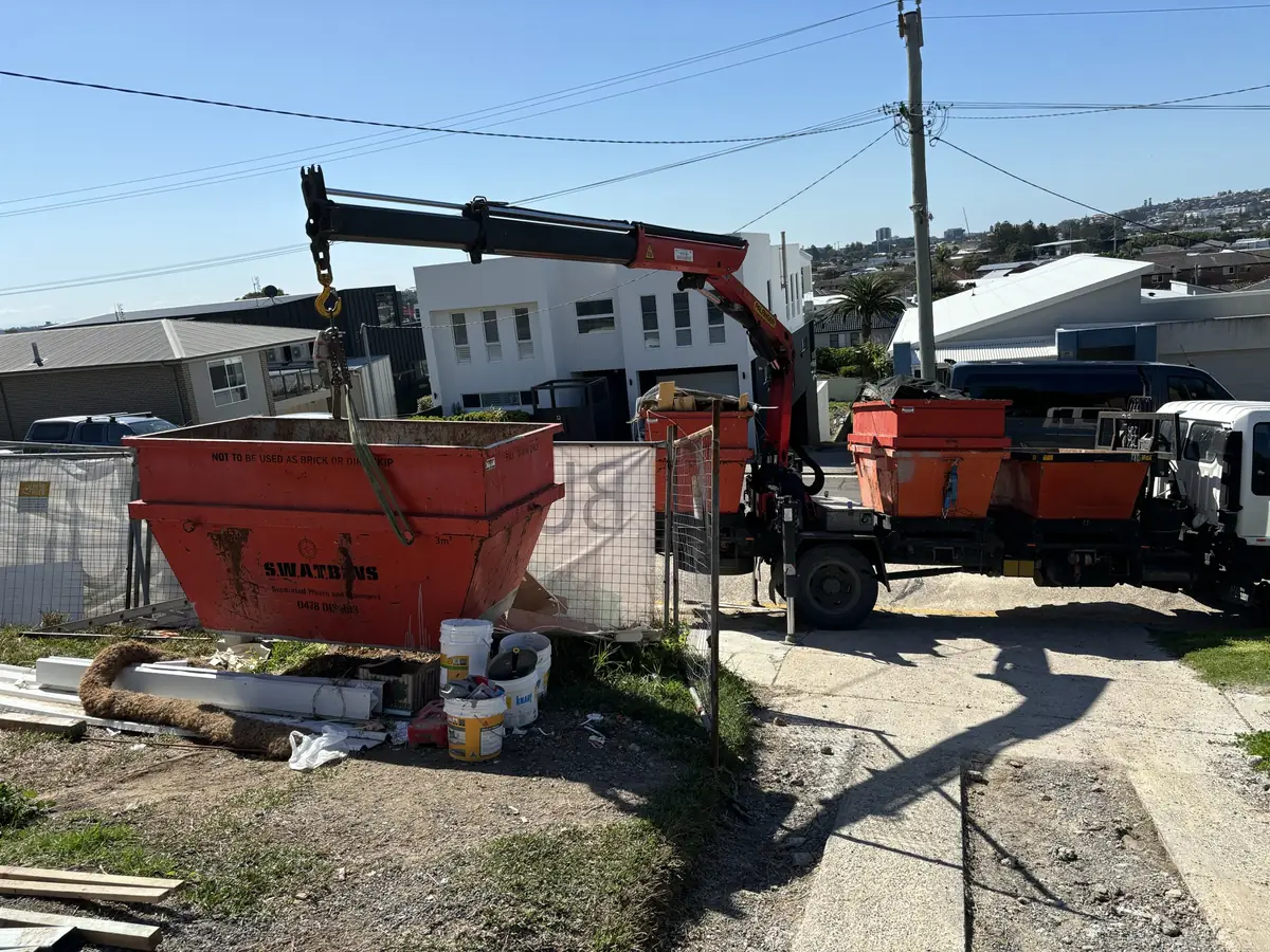 SWAT Bins crane swapping a skip bin on a residential building site